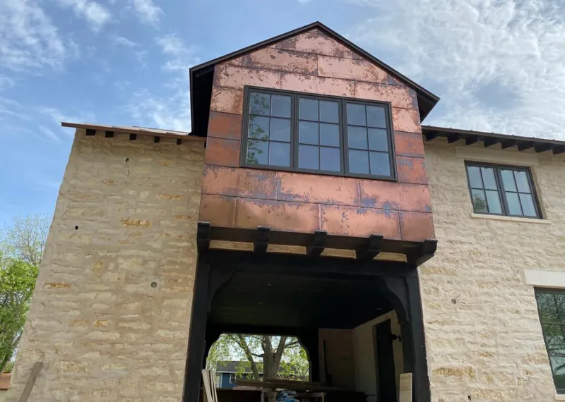 Copper metal panel facade on a stone building for Skylight Installation in Thief River Falls